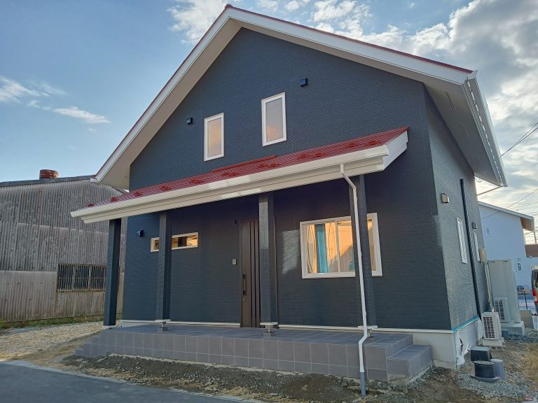 カバードポーチと赤い大屋根が印象的な外観に、ブラックの外壁を組み合わせた存在感抜群の住まい。