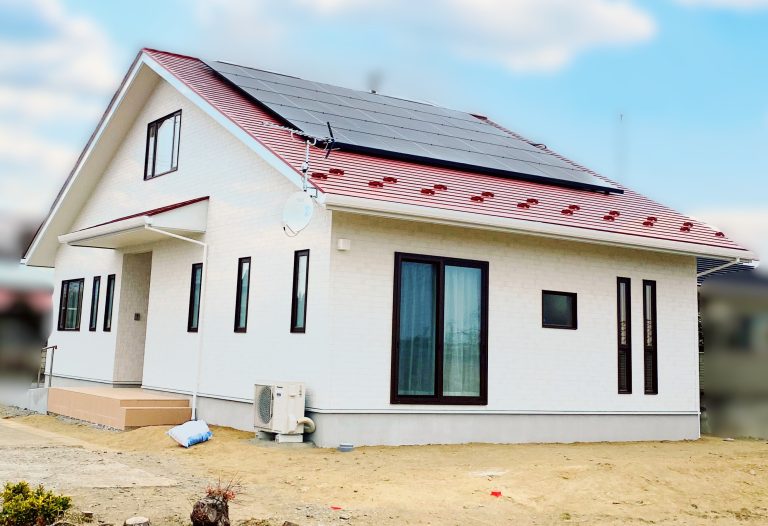 赤い大屋根に太陽光と白い外壁が目を引く、印象的な外観デザインの住まい。